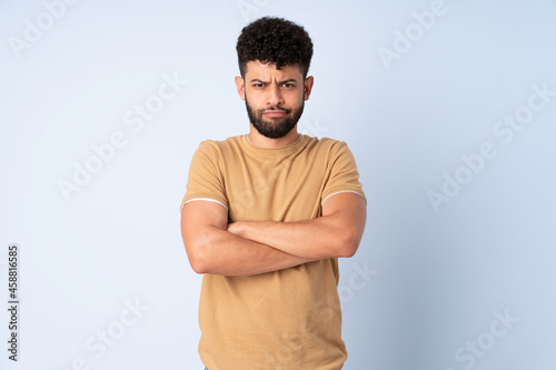 Young Moroccan man isolated on blue background feeling upset