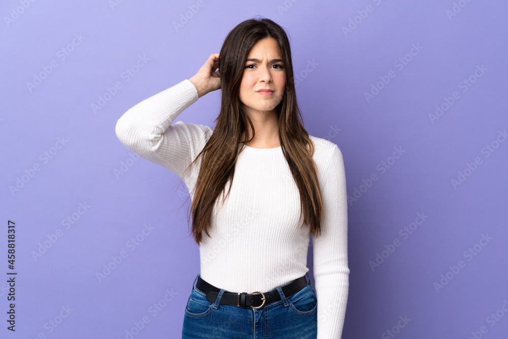 Teenager Brazilian girl over isolated purple background having doubts
