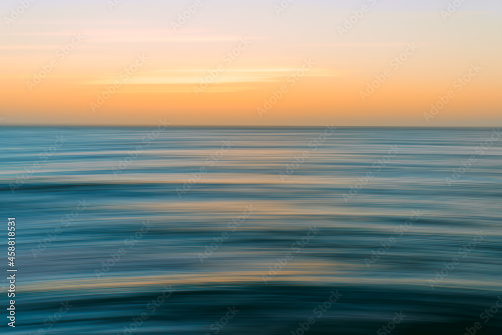 Sunset seascape abstract in bright blue, cyan, yellow colors, motion blur