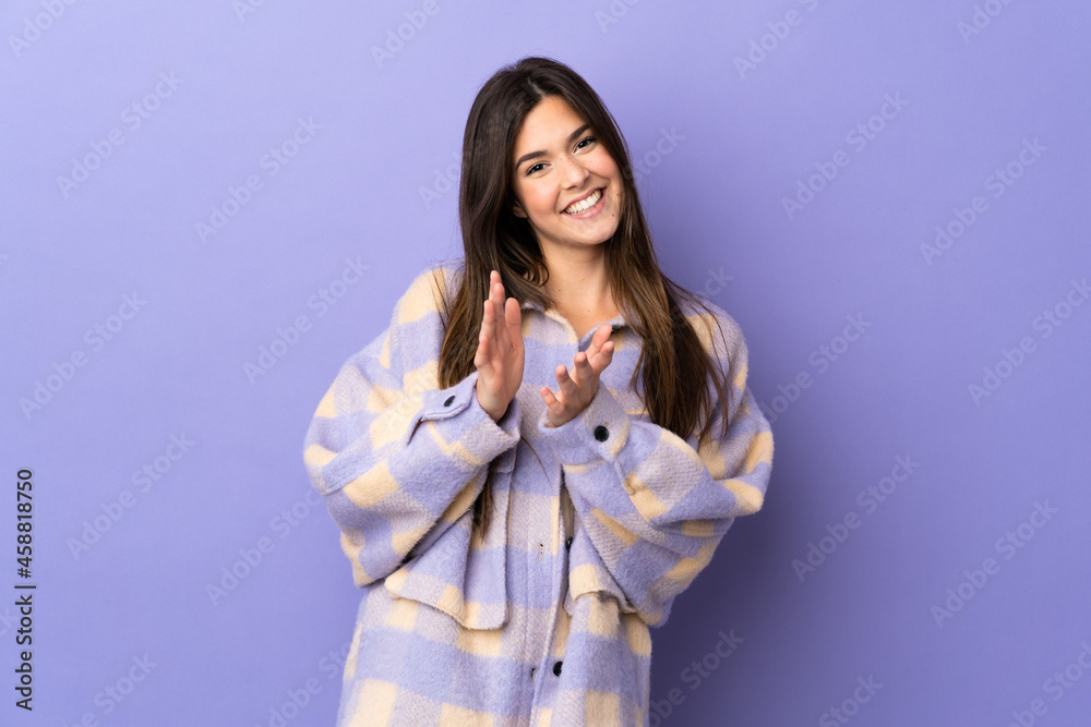 Teenager Brazilian girl over isolated purple background applauding after presentation in a conference
