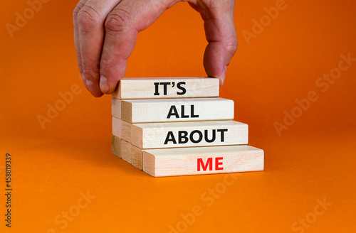 It is all about me symbol. Wooden blocks with words 'It is all about me'. Beautiful orange background. Businessman hand. Copy space. Business and it is all about me concept.