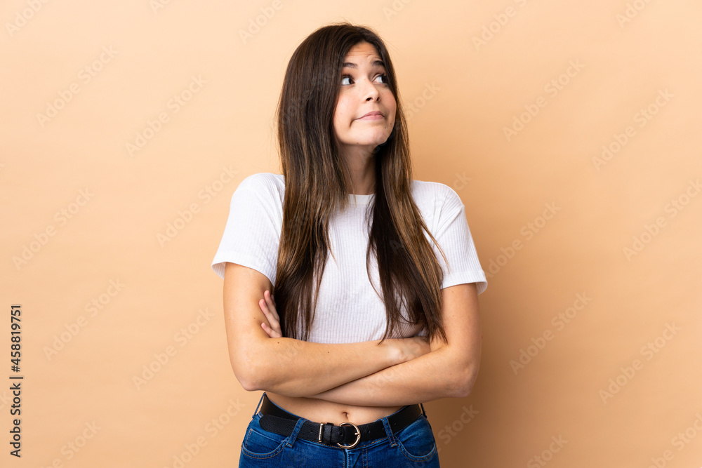 Teenager Brazilian girl over isolated background making doubts gesture while lifting the shoulders Teenager Brazilian girl over isolated background making doubts gesture while lifting the shoulders