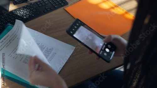 Female employee in espionage concept. Female hands take pictures of confidential documents in the office