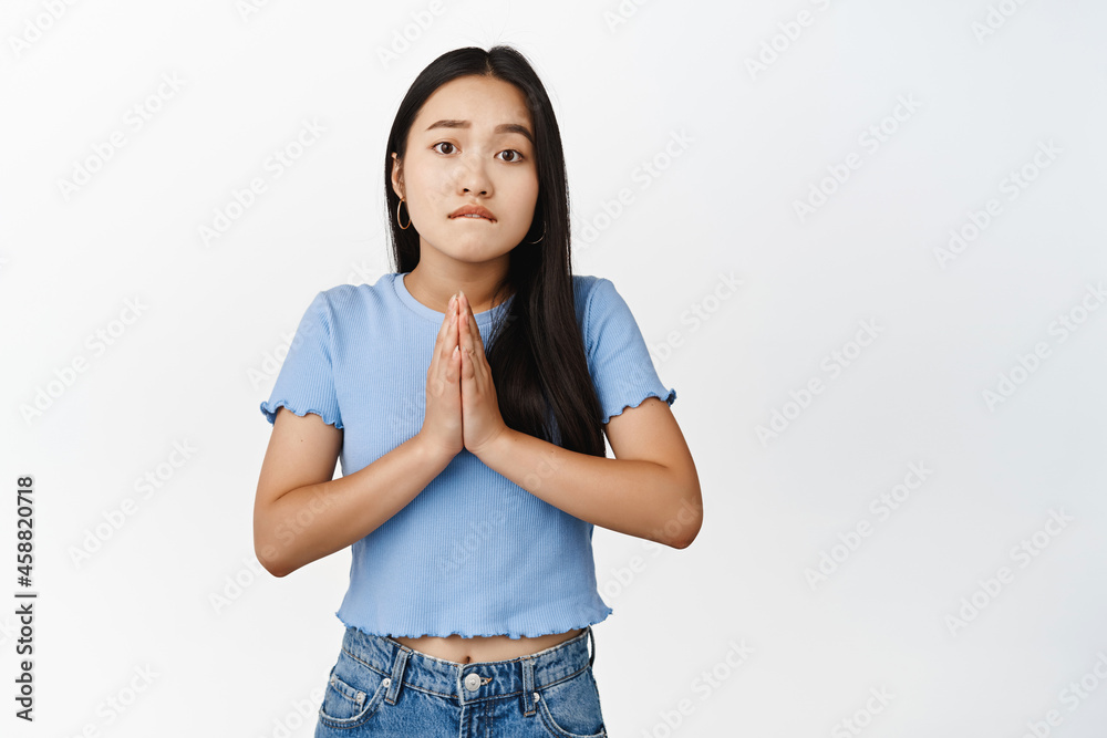 Young asian woman begging, asking for favour help, yearning to receive smth, standing over white background Young asian woman begging, asking for favour help, yearning to receive smth, standing over white background