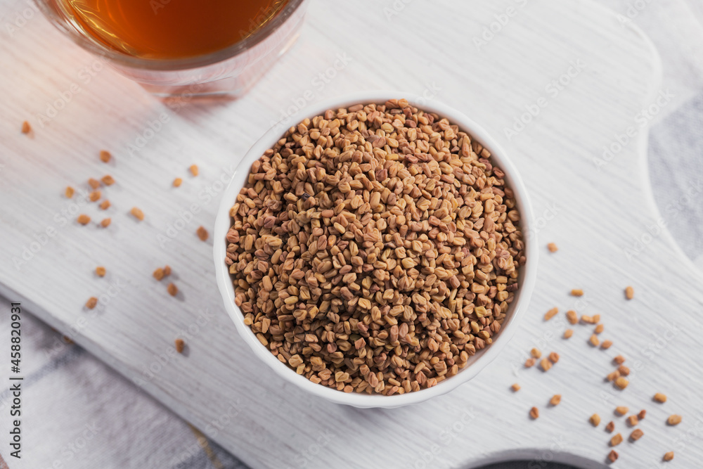 Bowl of fenugreek seeds and Egyptian fenugreek yellow tea or Methi Dana drink Bowl of fenugreek seeds and Egyptian fenugreek yellow tea or Methi Dana drink