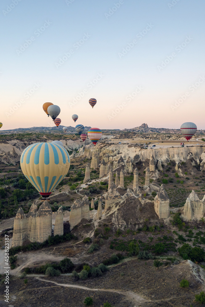 Colorful hot air balloons in the sunrise autumn morning. Goreme National Park, Cappadocia, Turkey. Aerial view