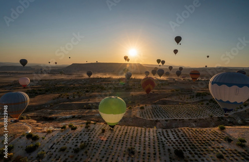 Panoramic view of bunch of colorful hot air balloon flying against sunrise in Cappadocia, Turkey in love valley located in Goreme national park