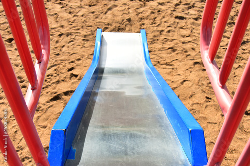 An image of a brightly colored slide on a children's playground. 