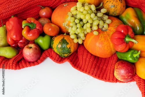 Fototapeta Naklejka Na Ścianę i Meble -  Thanksgiving Day. Big autumn harvest - pear, apples, pumpkin, pepper, tomato on a white background and red cloth. Thanksgiving celebration concept, top view.