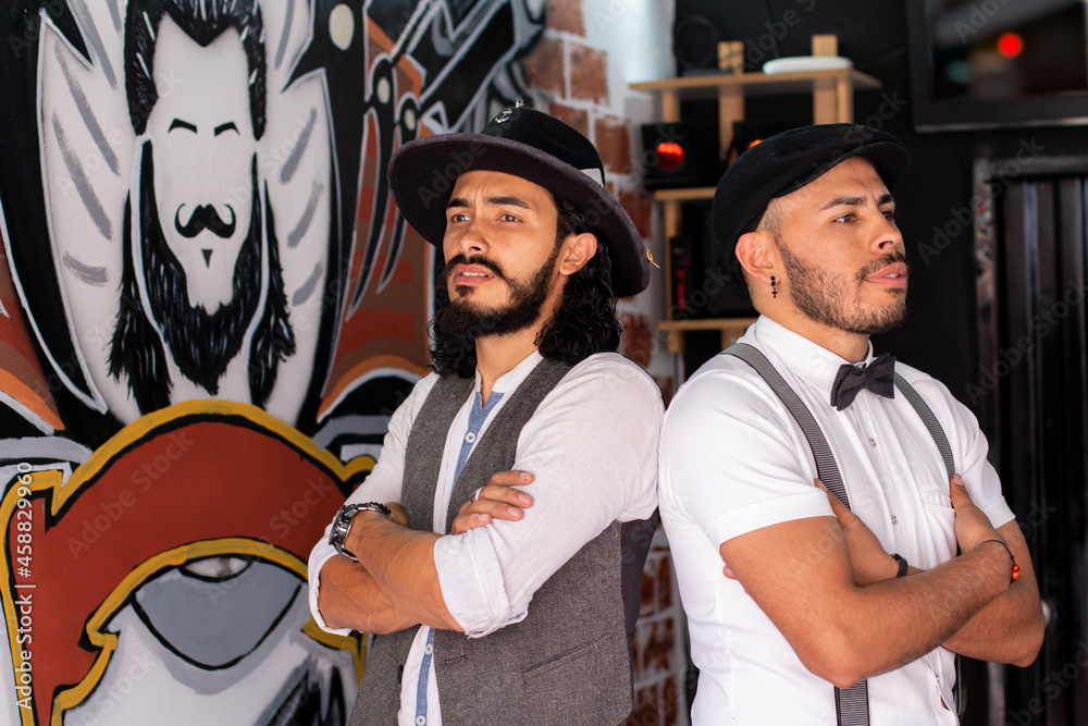 Fototapeta premium Barberos elegantes posando con los brazos cruzados en su barberia. Hispsters.