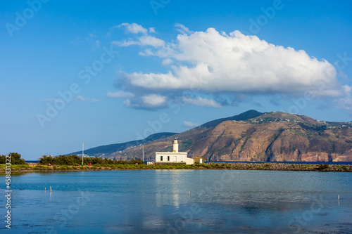 Salina island (Aeolian archipelago), Messina, Sicily, Italy, 08.17.2021: view of the salt lake with the white lighthouse in the background in Punta Lingua.