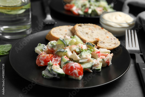 Delicious salad with mayonnaise on black table