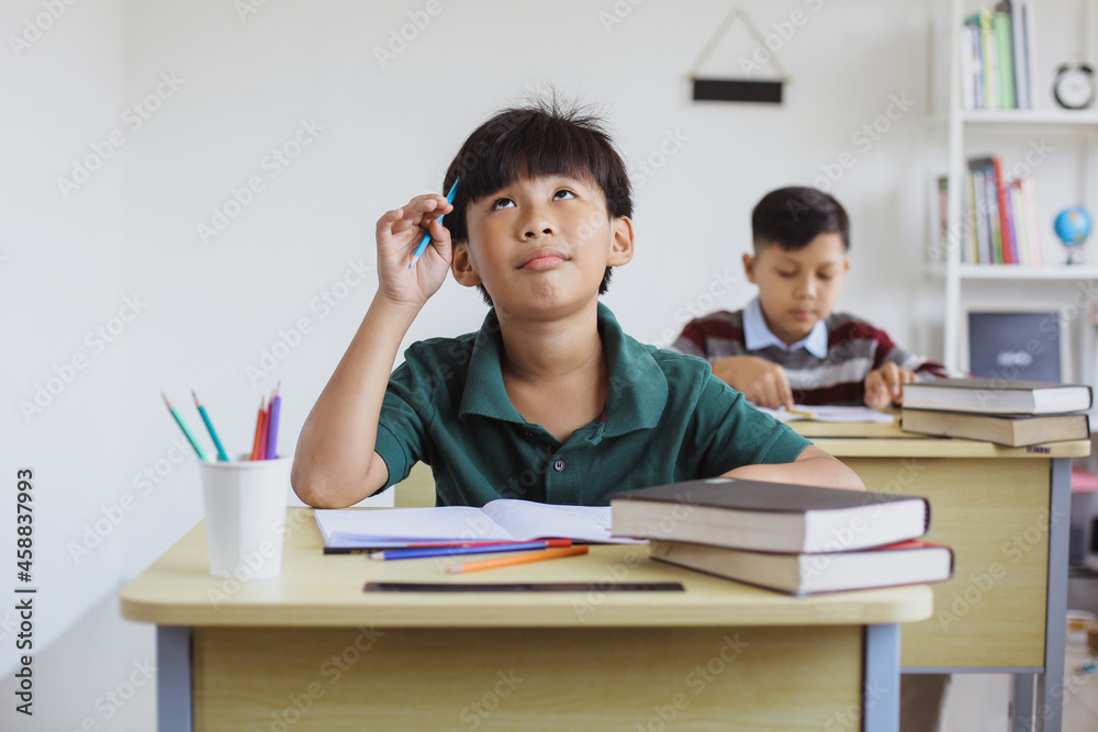 Confused llementary school boy when doing exams in class Confused llementary school boy when doing exams in class