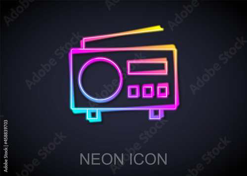 Glowing neon line Radio with antenna icon isolated on black background. Vector