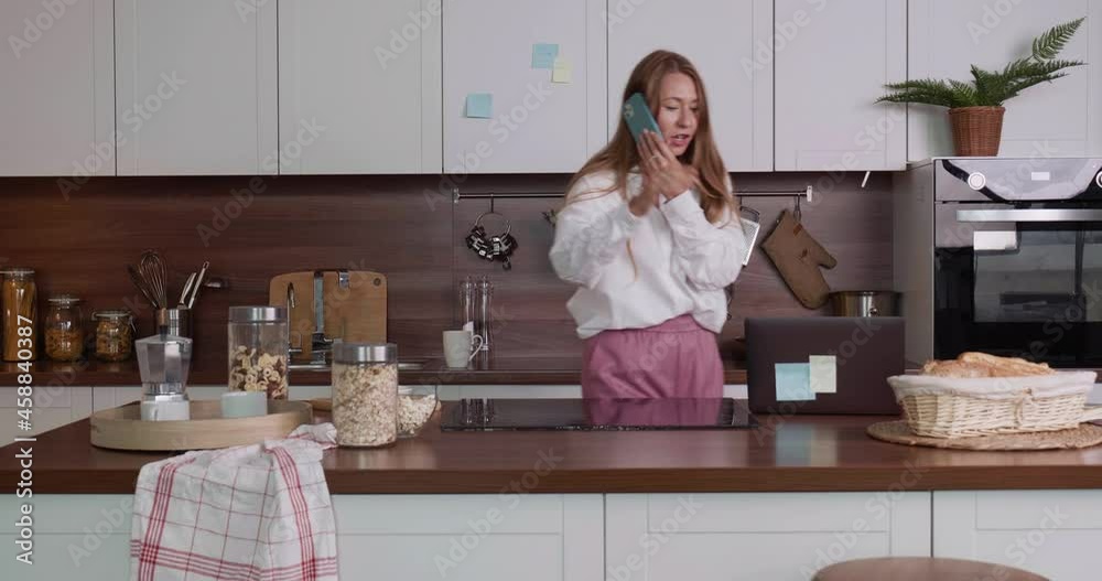 Stressed young business woman rushing in the kitchen after oversleep, taking laptop, sipping coffee running late to work Stressed young business woman rushing in the kitchen after oversleep, taking laptop, sipping coffee running late to work