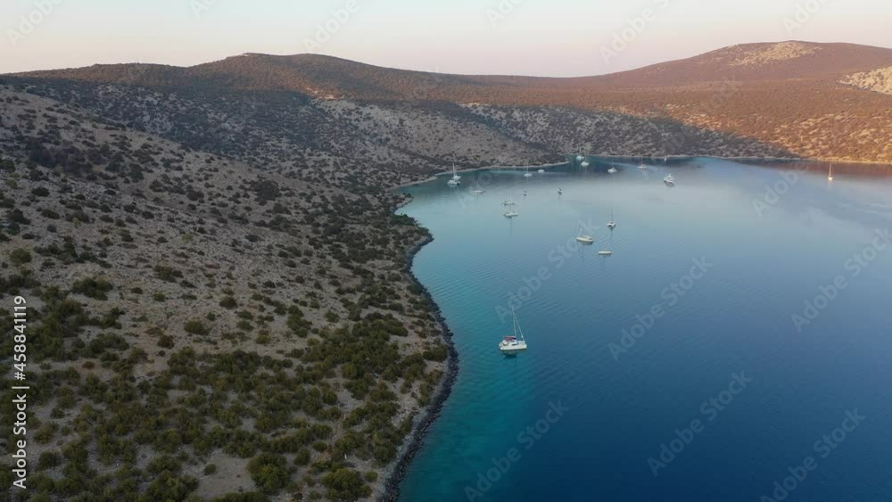 Catamaran and sail Yachts anchored at bay on deep blue sea water on sunrise Catamaran and sail Yachts anchored at bay on deep blue sea water on sunrise