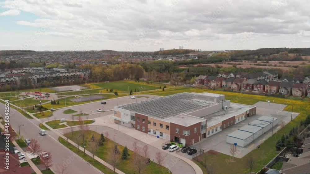 A modern new school built in a subdivision is topped with solar panels.