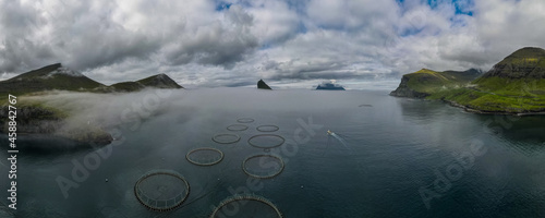 Beautiful aerial view of the Salmon fishing farm pools and boat in the Faroe islands 