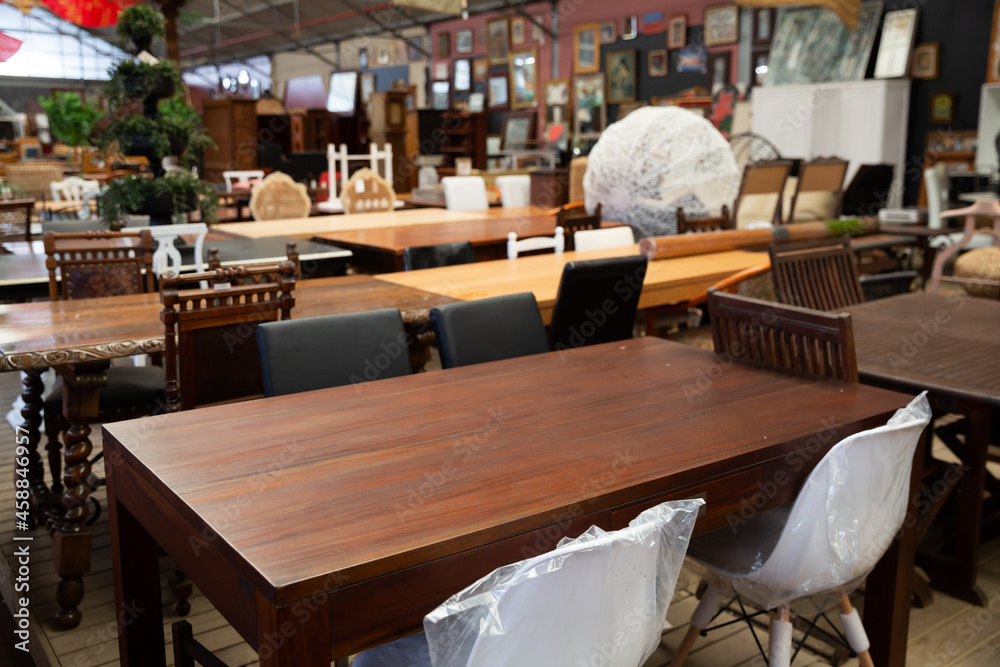 Interior of modern furniture shop with variety of dining room tables, chairs and sets for sale