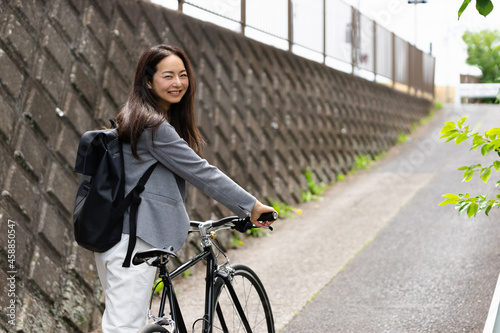 笑顔で振り向く女性・自転車の通勤イメージ