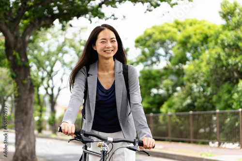 笑顔で自転車通勤する女性・スマートフォンの操作