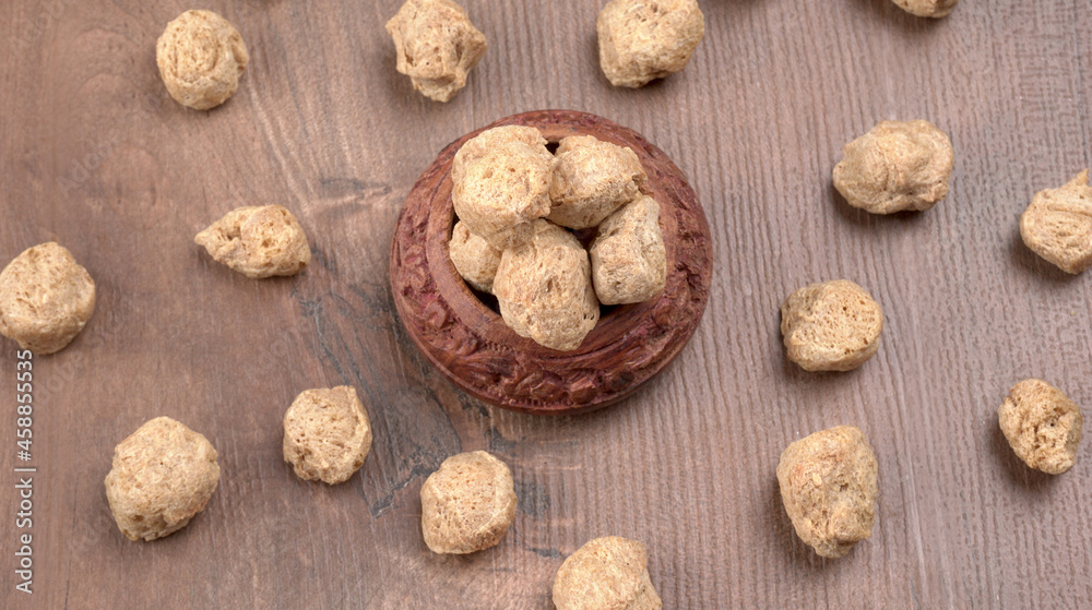 Raw soya chunks on dark background. Healthy, nutritious soybean meat, chunks isolated.Vegan food concept.
