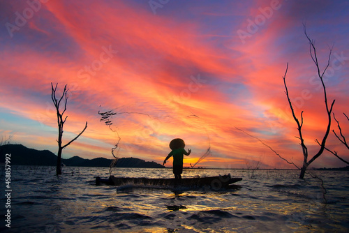 Fototapet Silhouettes of the traditional stilt fishermen at sunset.