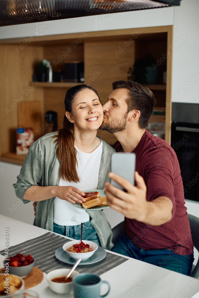 Happy couple in love takes selfie while having breakfast together at home. Happy couple in love takes selfie while having breakfast together at home.