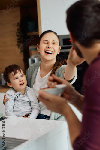 Young playful family has fun while having breakfast together at home. © Drazen