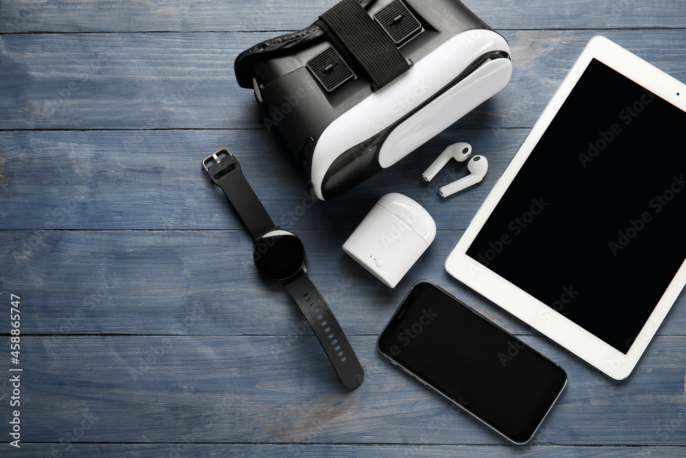 Different modern devices on color wooden background Different modern devices on color wooden background