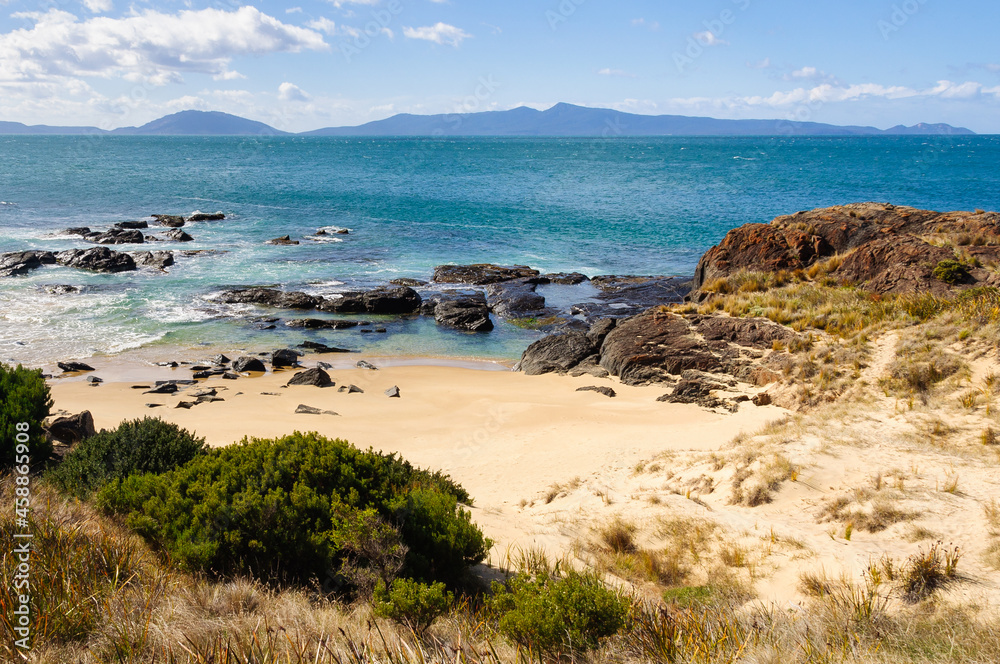 Spiky Beach is a remote sandy beach with a rocky shore surrounded by low hills - Swansea, Tasmania, Australia
