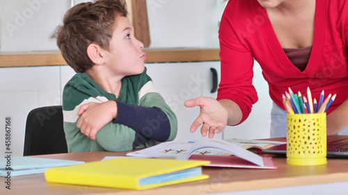 angry serious mum lecturing lazy unmotivated schoolboy, children education problem, parent and child conflict. Stressed mother and son frustrated over failure homework. photo