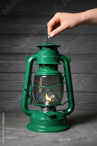 Woman holding retro lamp on...