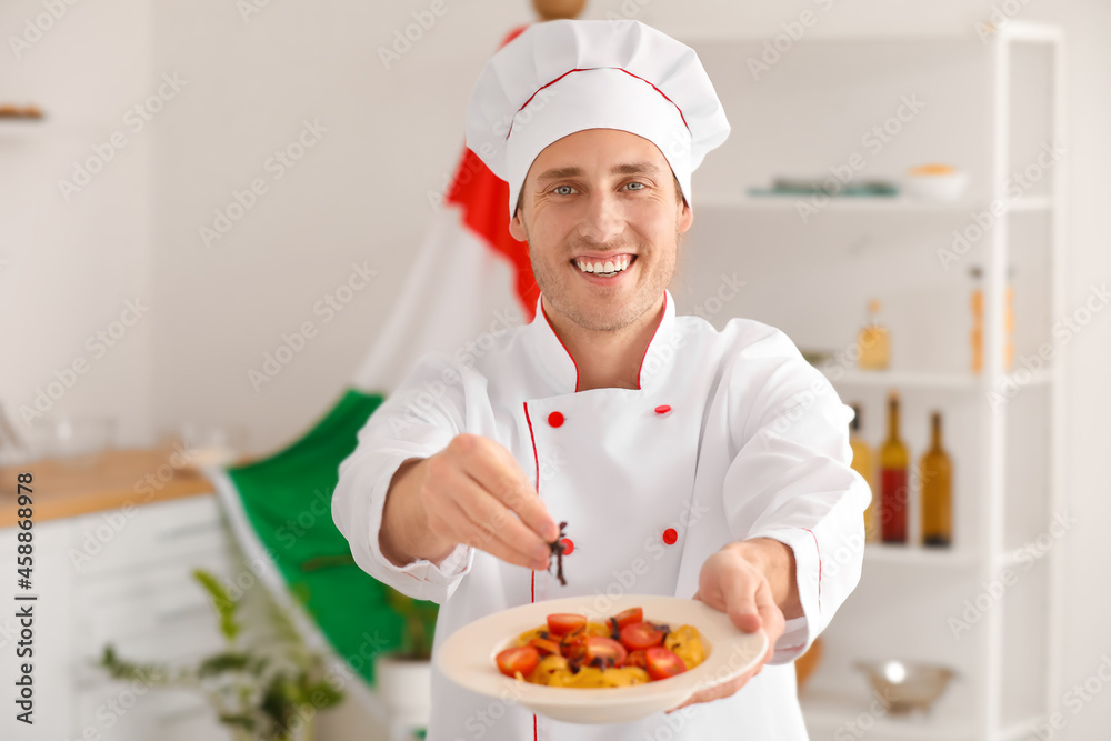 Italian chef with delicious pasta and basil in kitchen