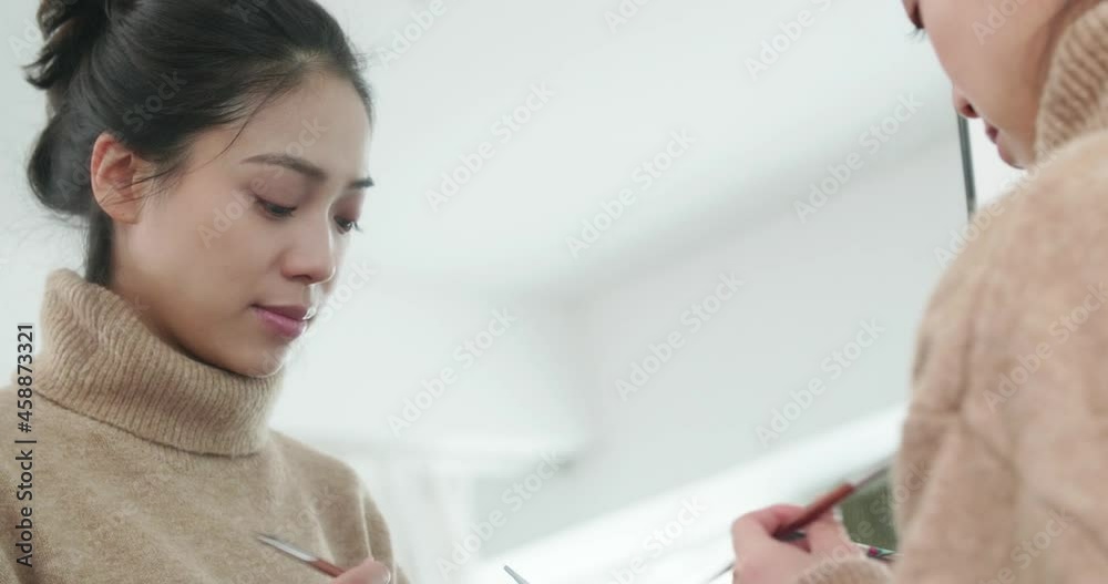 Young Asian woman applying eyeshadow in front of the mirror make-up at home Young Asian woman applying eyeshadow in front of the mirror make-up at home