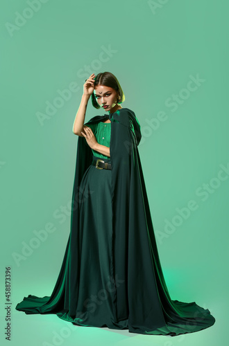 Beautiful woman dressed as witch for Halloween on color background