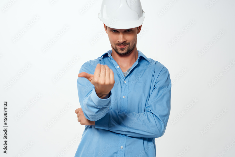 male builder in a white helmet construction industry light background male builder in a white helmet construction industry light background