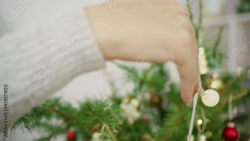 A young man decorates a Christmas tree vintage balls. Hands close-up. Merry Christmas and Happy Holidays. .The morning before Xmas. Banner with copy space.