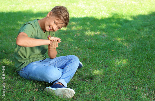 Little boy with snail in park