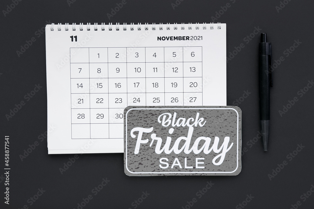 Calendar page of November 2022 and pen on dark background. Black Friday Calendar page of November 2022 and pen on dark background. Black Friday