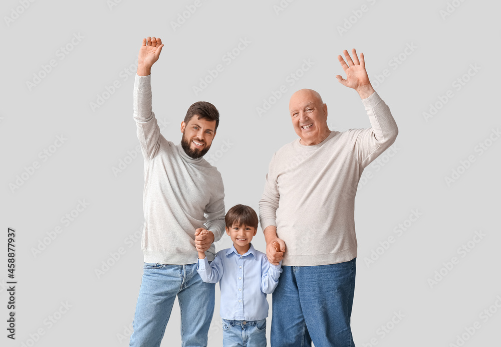 Happy man, his little son and father on light background