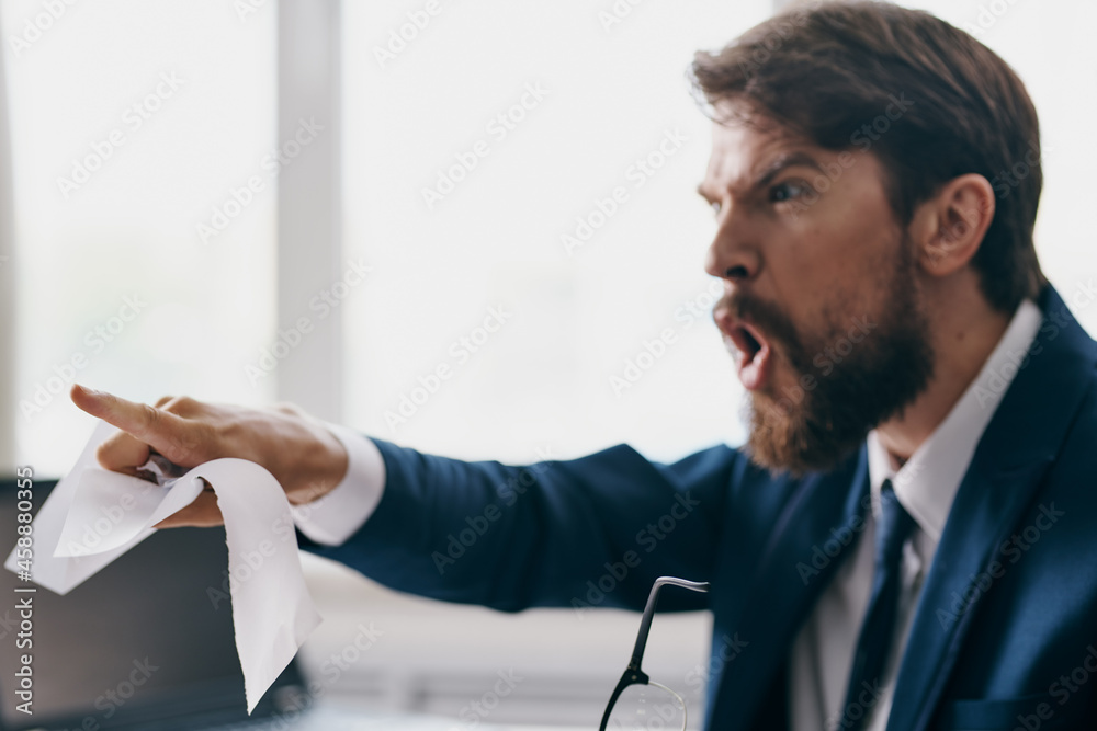 businessmen sitting at a desk in front of a laptop stress anger professional