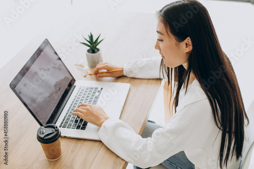 Woman checking graphs on stock market on computer © Petro