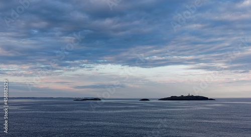Low lying Islands rising out of the calm Sea in the Fjord close to Bergen on Norways Western Coast at Dawn. photo