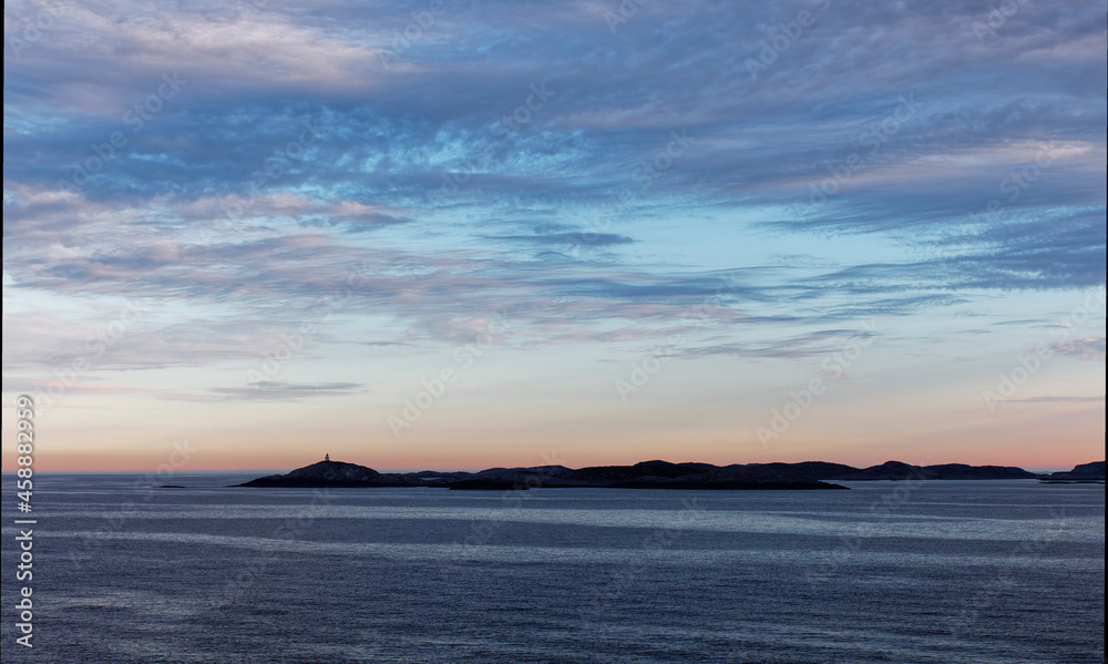 Fototapeta premium Low lying Islands silhouetted in the Early Morning Light on the Norwegian West Coast near to Bergen, on a calm Morning.