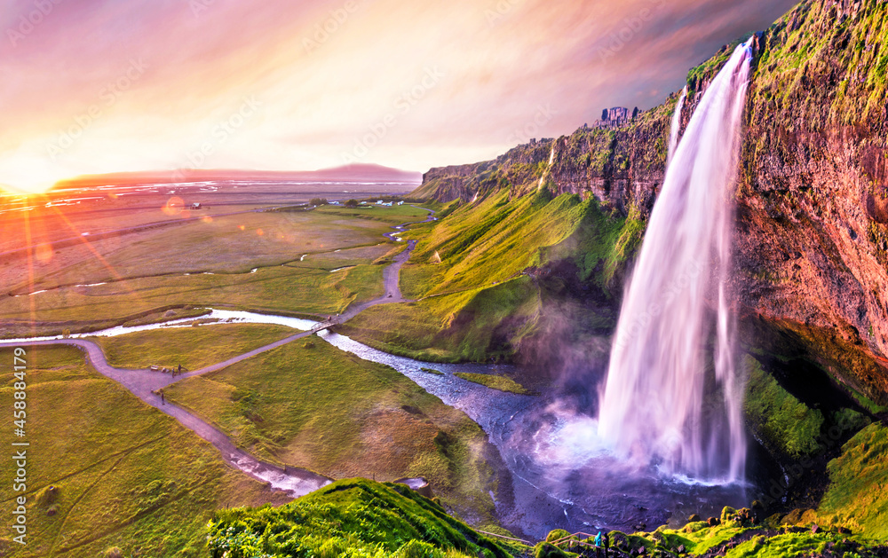 Charming beautiful waterfall Seljalandsfoss in Icelandat sunset. Exotic countries. Amazing places. Popular tourist atraction.
