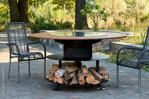 Kettle Grill Pit with Cast Iron Grid with flames . Round table-cooking surface. Hot BBQ on Backyard