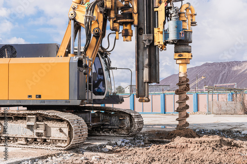 Powerful hydraulic drilling rig on a construction site. Installation of bored piles by drilling. Pile foundations. Drilling in the ground.