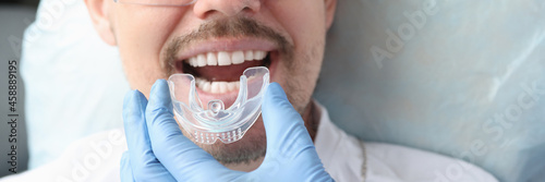 Dentist trying on mouthguard for man patient photo