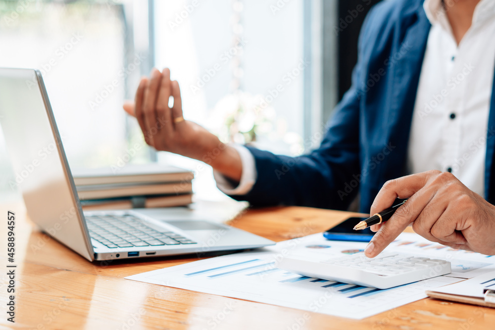 Close up of accountant or banker checking investment results, calculates financial savings, calculates annual taxes and economic concepts. Financial calculation concept. Close up of accountant or banker checking investment results, calculates financial savings, calculates annual taxes and economic concepts. Financial calculation concept.